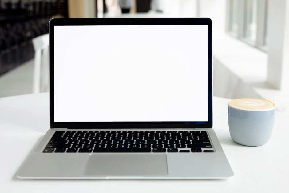 Un écran d’ordinateur moderne affichant des travaux de web design, mettant en avant des visuels créatifs dans un espace de travail.